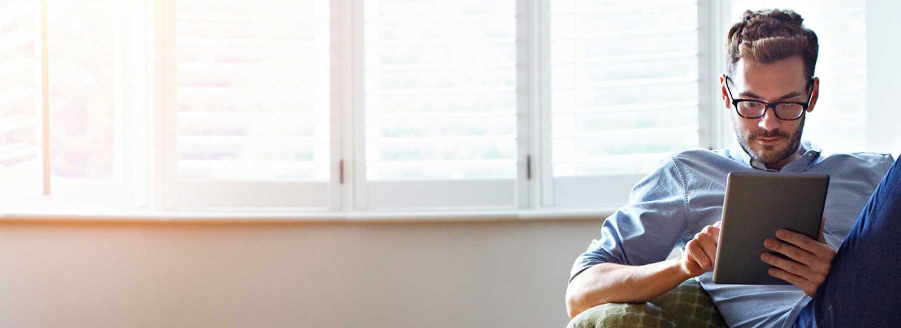 Se muestra a un hombre pensativo viendo su dispositivo mientras está sentado Se muestra a un hombre pensativo viendo su dispositivo mientras está sentado